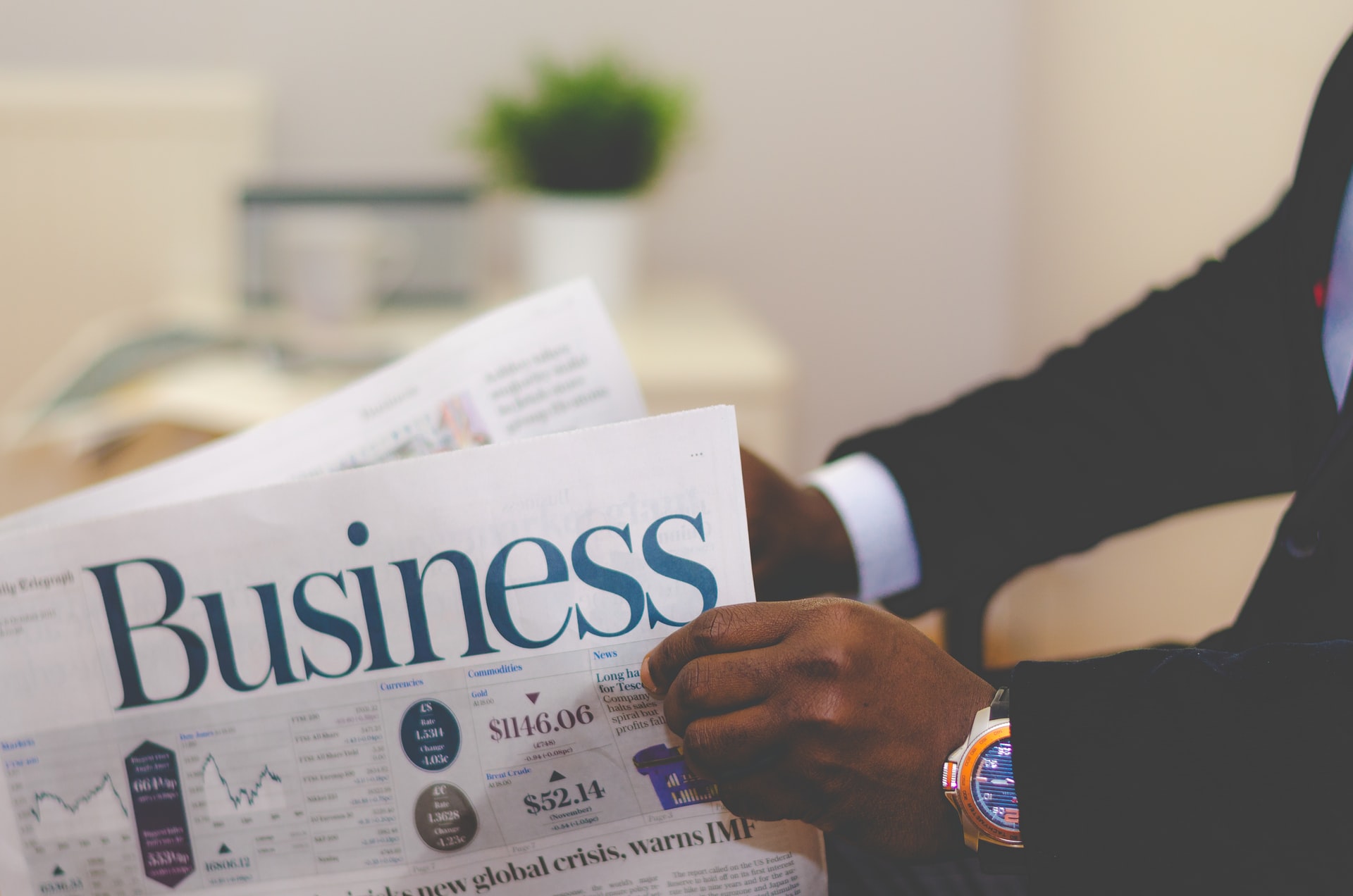 A man wearing a suit reading business newspaper