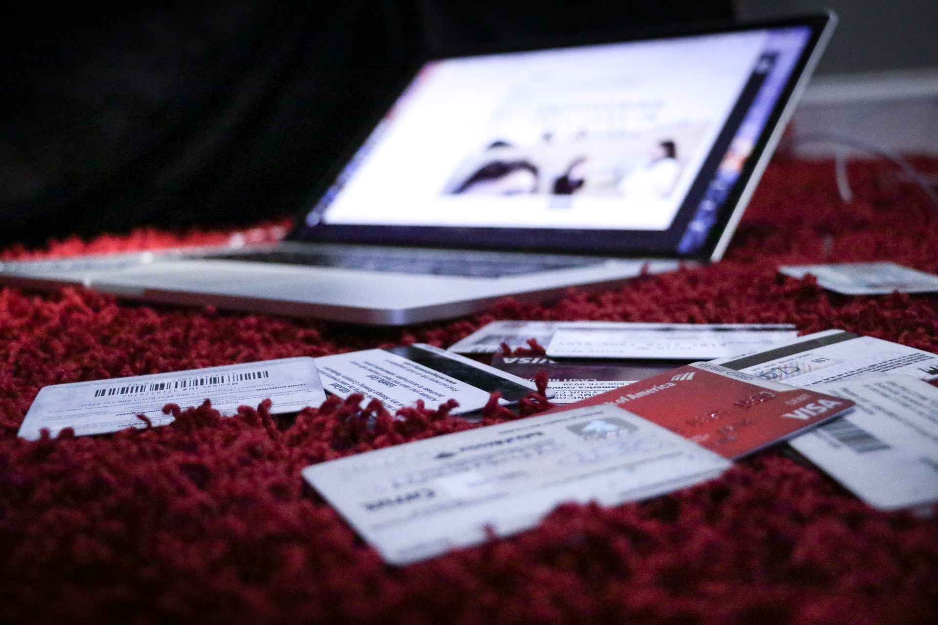 Bed littered with credit cards next to laptop