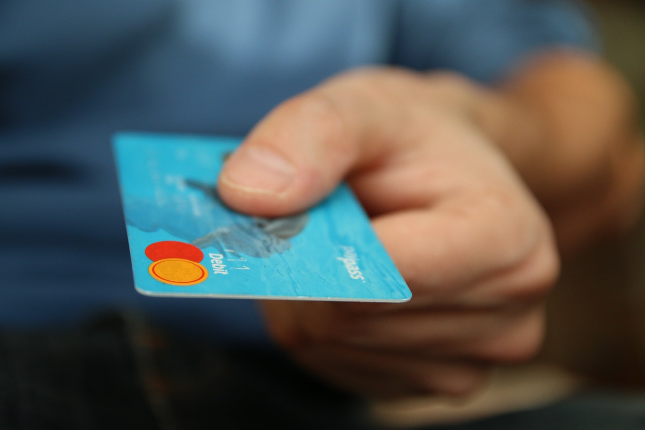 Hand holding out a credit card