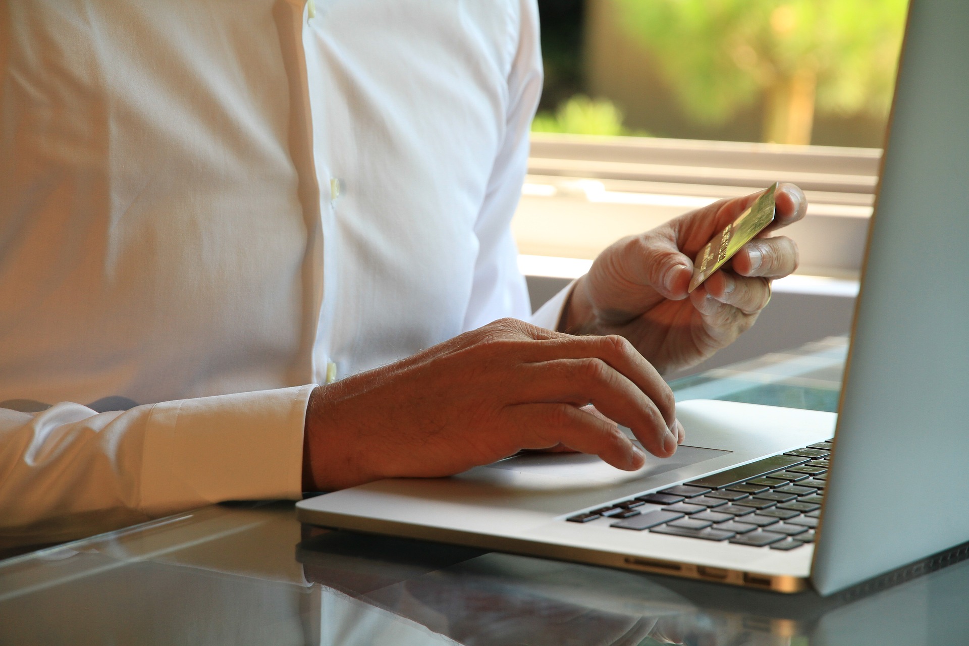 A man using a credit card to make an online payment on his laptop