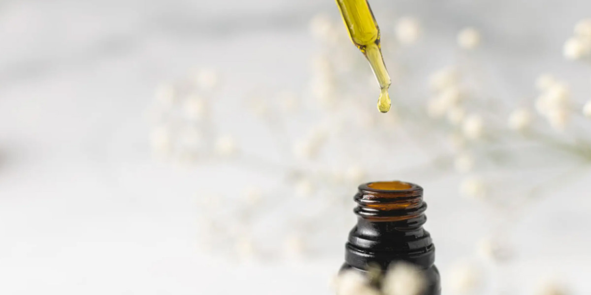 A dropper dropping CBD into a vial.