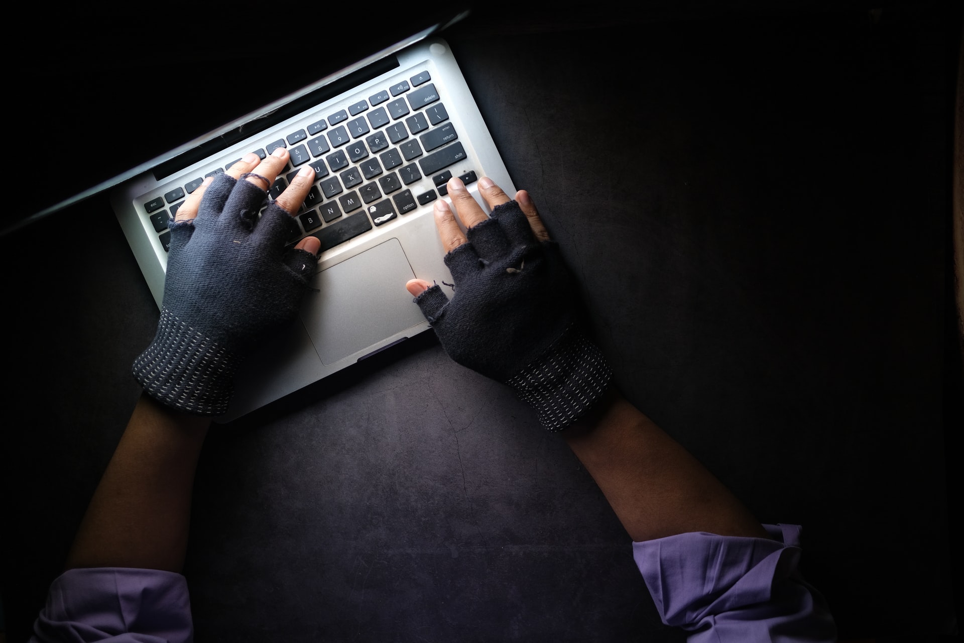 Gloved Man Typing on Computer