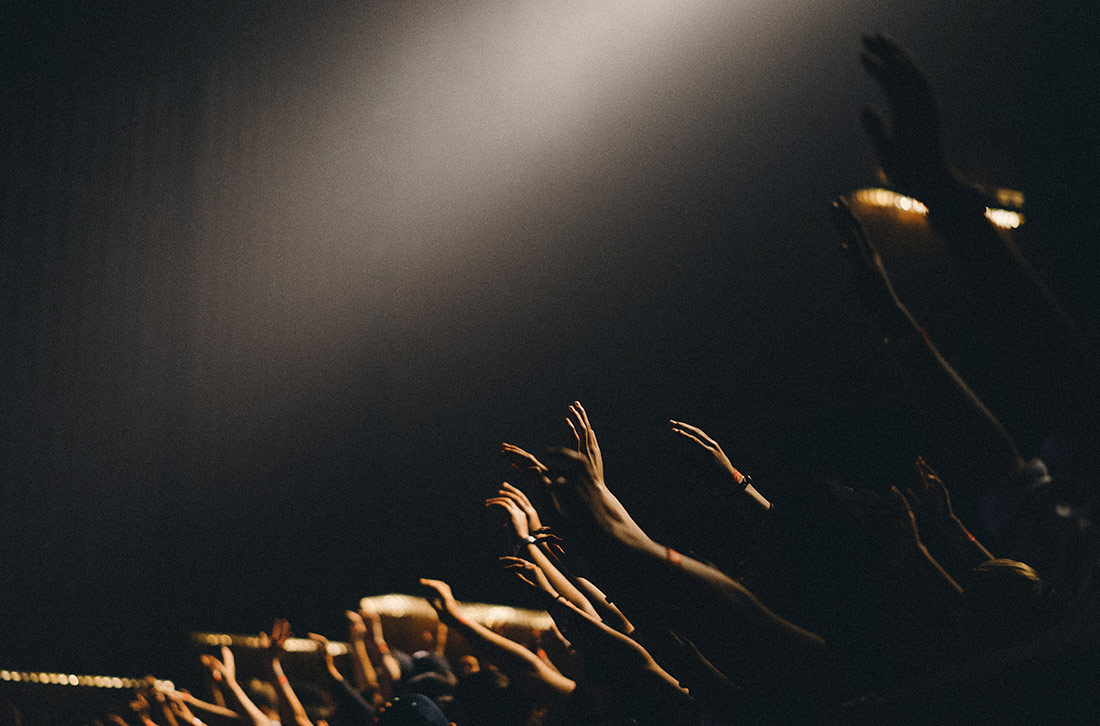 Hands Raised in Auditorium